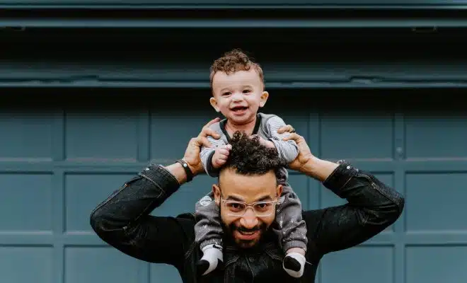 Un papa portant son enfant sur les épaules
